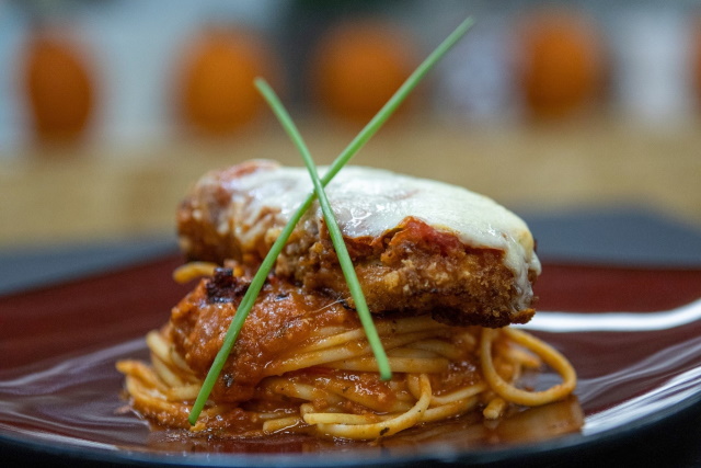 Plate of chicken parmesan on spaghetti pasta